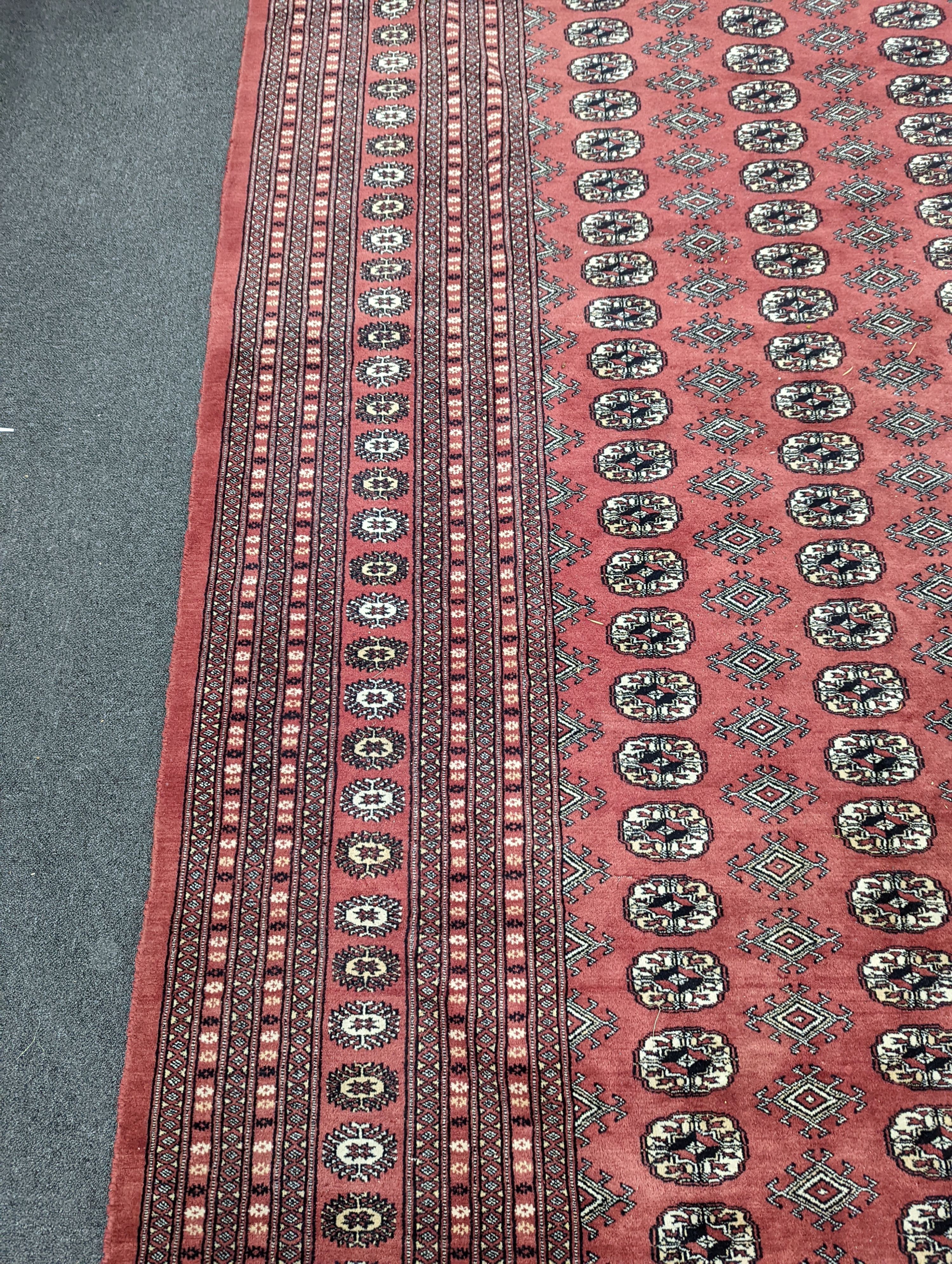 A Bokhara burgundy ground carpet, 360 x 276cm